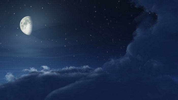 Half moon in a starry night sky with clouds