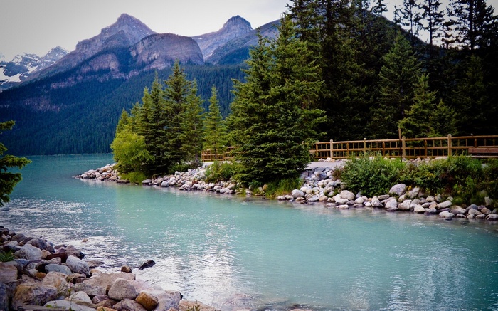 Turquoise lake with mountains and pine trees