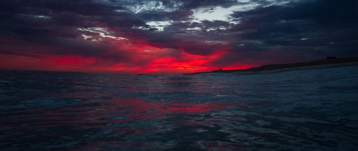 Crimson sunset over the ocean waves