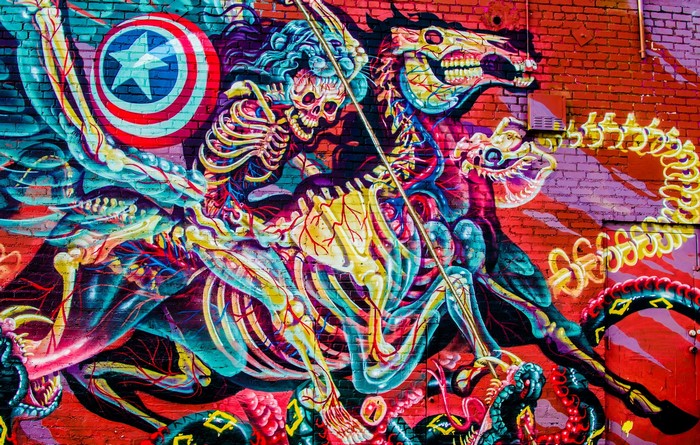Graffiti of skeletal figures on a brick wall