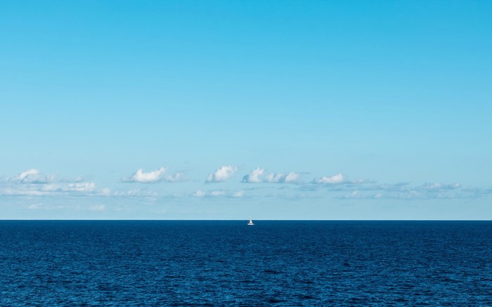 Minimalist Sea and Boat Under Clear Blue Sky