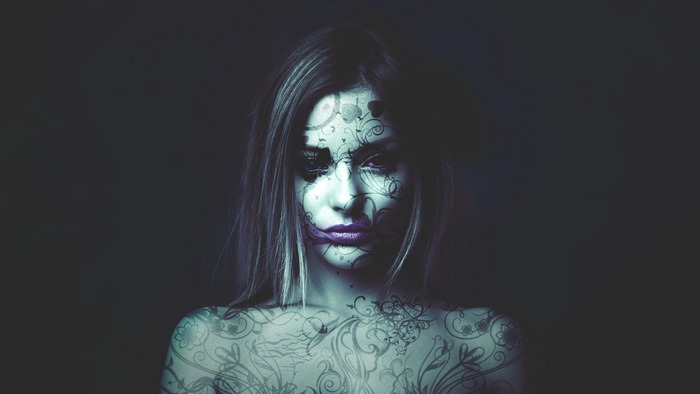 Woman with abstract tattoos and purple lips