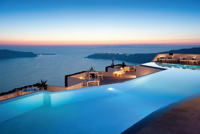 Infinity pool overlooking the sea at sunset in Santorini, Greece