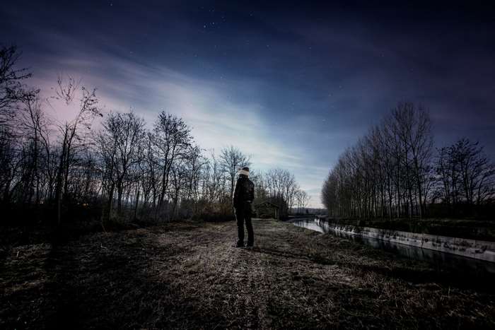 Man standing alone under starry night sky