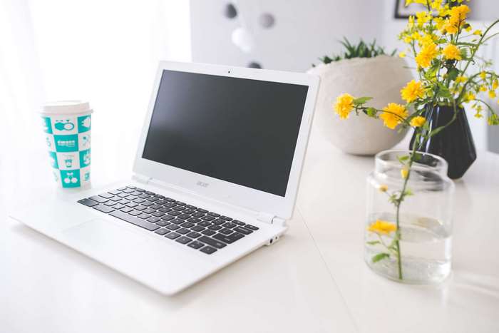 White Acer Chromebook laptop with coffee and flowers