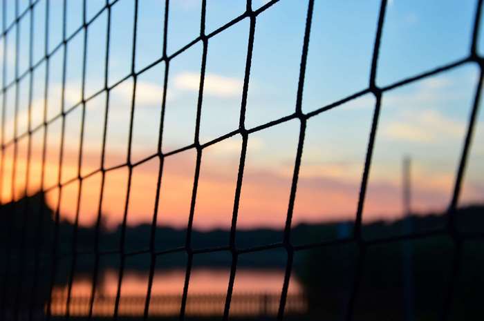 Sunset View Through a Volleyball Net by the Lake