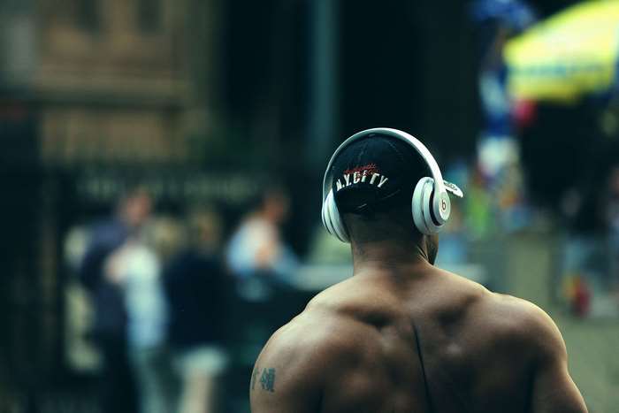 Man wearing headphones and a cap with 'N.Y.C.F.T.Y.' text