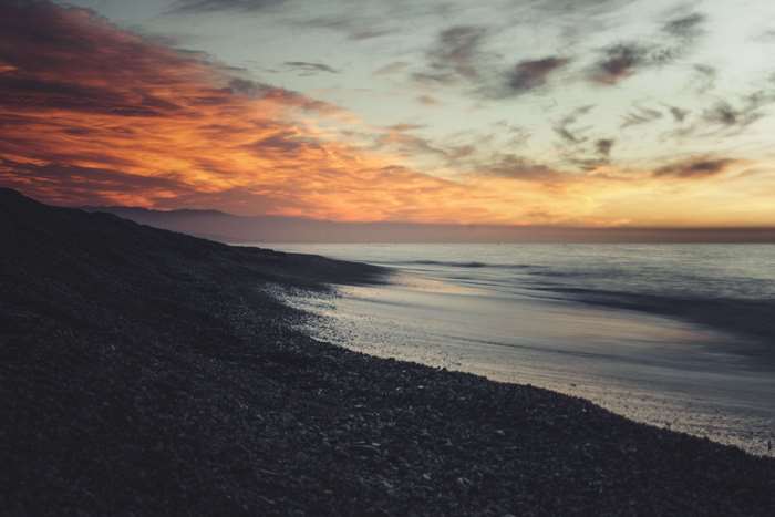 Sunset over a rocky beach and ocean