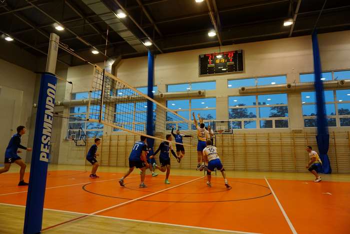 Volleyball game in a gymnasium with scoreboard