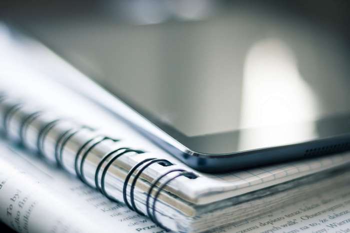 Tablet on a Spiral Notebook and Book