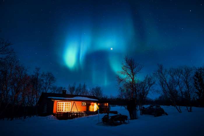 Cabin under Aurora Borealis in winter 4K