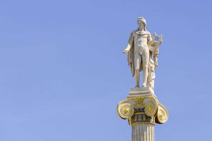 Statue of Apollo holding a lyre on a column in Athens, Greece