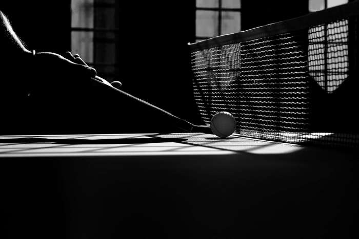 Table tennis racket and ball near net