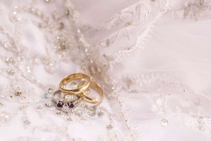 Wedding rings on a white lace dress