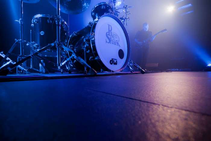 Drum set and guitarist on stage