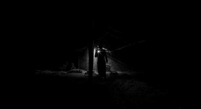 Man with flashlight in dark building