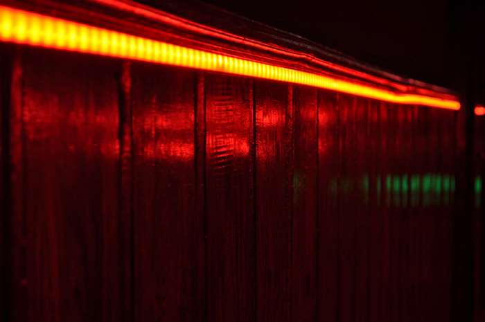 Red LED strip light on a wooden wall