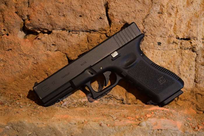 Glock 17 handgun on brick wall