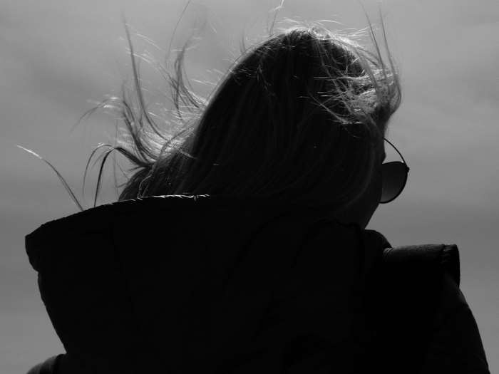 Girl with hair blowing in the wind, black and white 4K