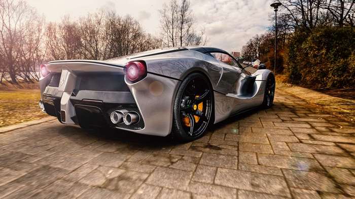 Silver Ferrari sports car on a brick path