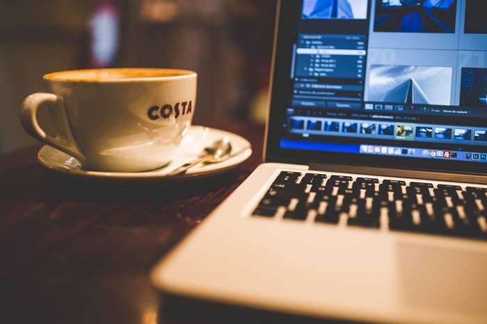 Costa coffee cup and MacBook laptop