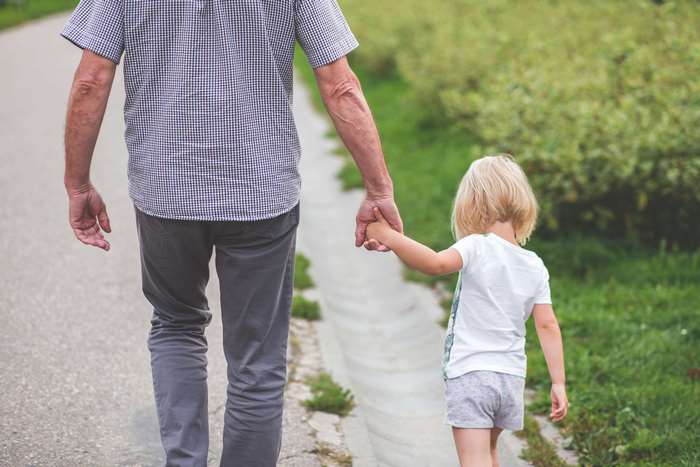 Man and child holding hands walking outdoors