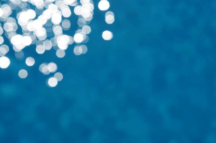 Blue water surface with sun sparkles