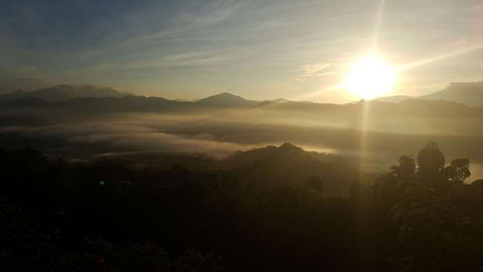 Sunrise over foggy mountains with sun rays