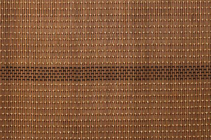 Brown bamboo mat with gold and black woven pattern