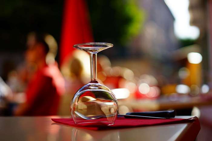 Wine glass on a table with cutlery and napkin
