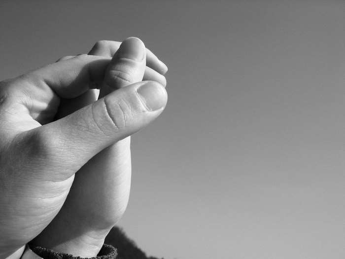 Close up of two hands holding fingers