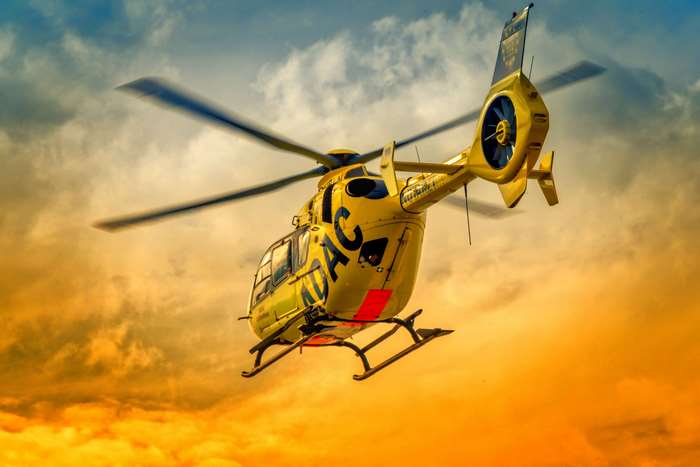 Yellow helicopter flying at sunset 4K