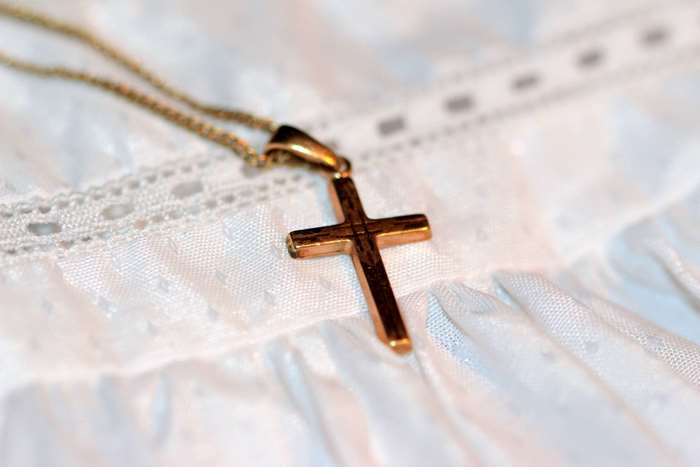 Gold cross on a white christening gown
