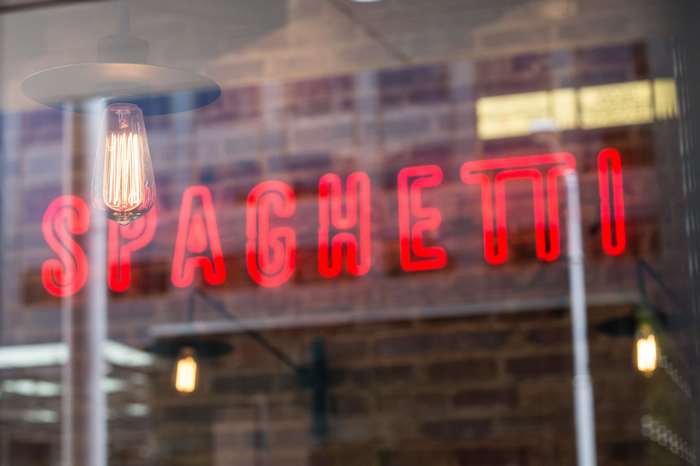 Red neon spaghetti sign in a shop window