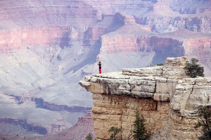 Man standing on cliff edge at Grand Canyon