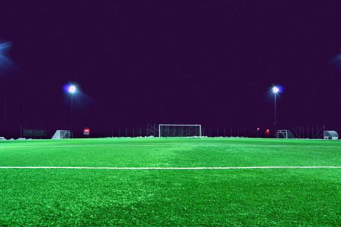 Soccer field at night with spotlights and goals