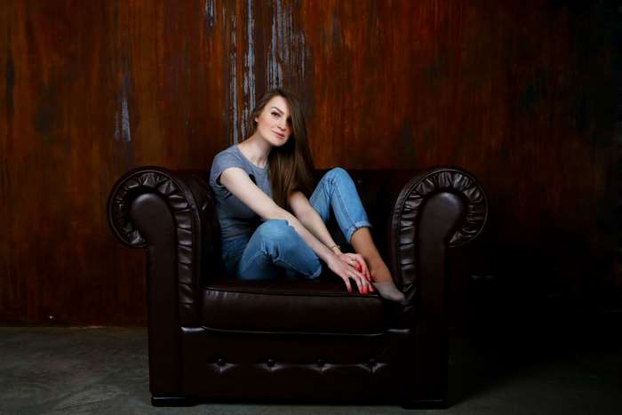 Young woman sitting in a leather armchair