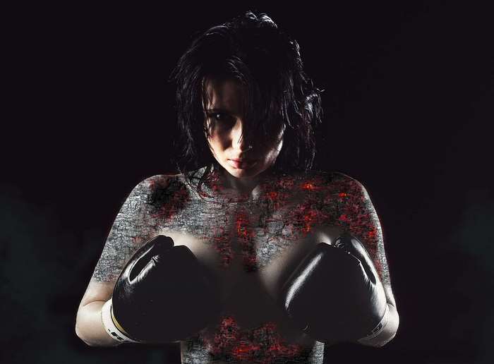 Woman boxer with textured skin and black gloves