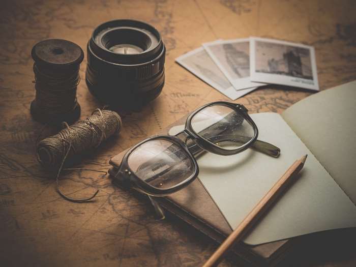 Vintage travel items on a map with photos and glasses