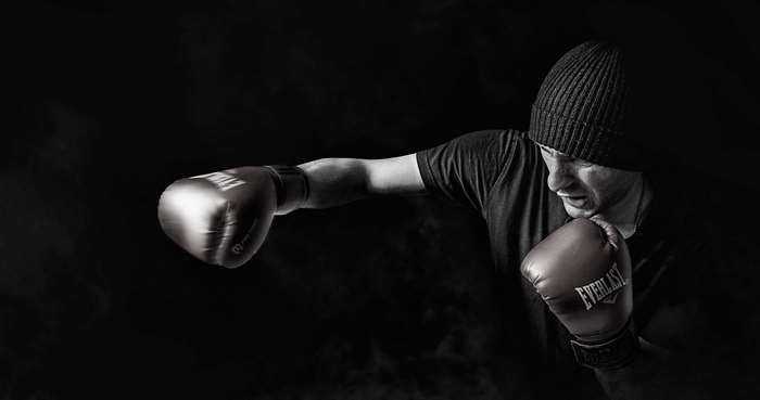 Boxer in black beanie and Everlast gloves training