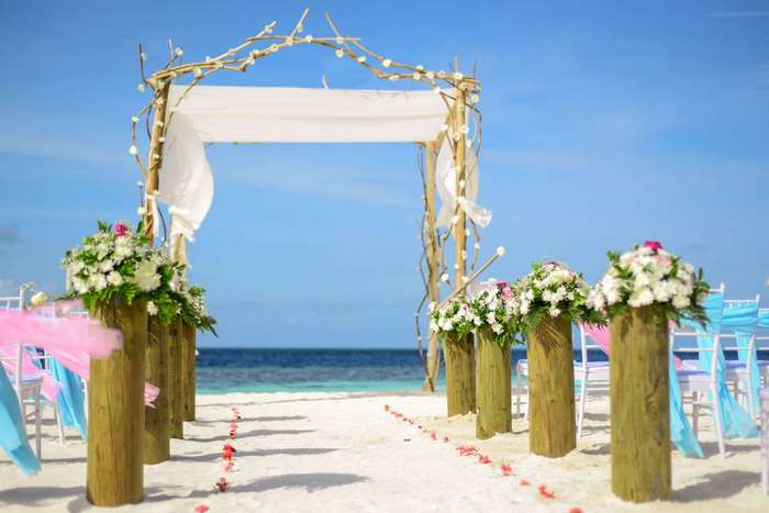 Beach wedding setup with floral decorations and ocean view