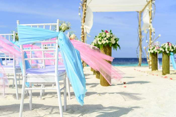 Beach wedding setup with chairs and floral decorations