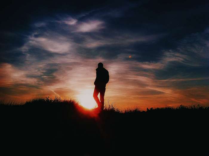 Silhouette of a person against a sunset sky