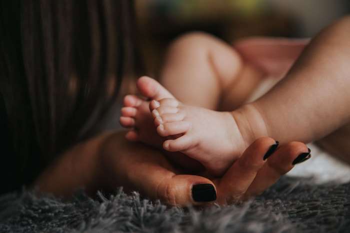 Mother holding newborn baby's feet