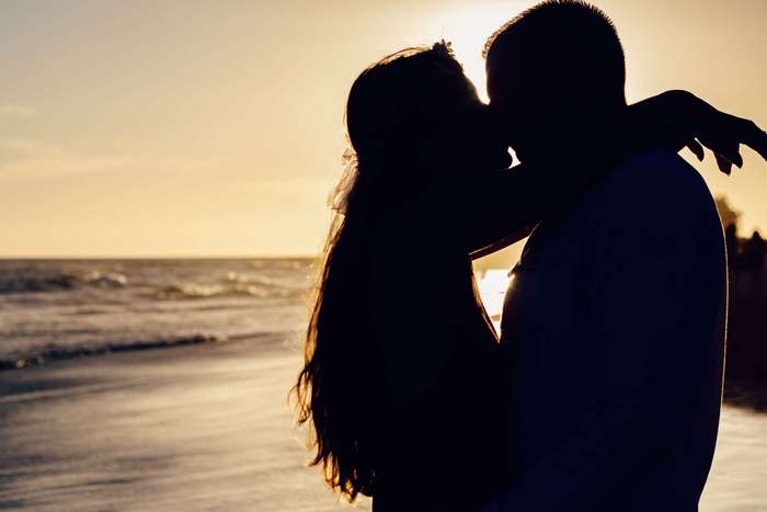 Couple kissing on a beach at sunset