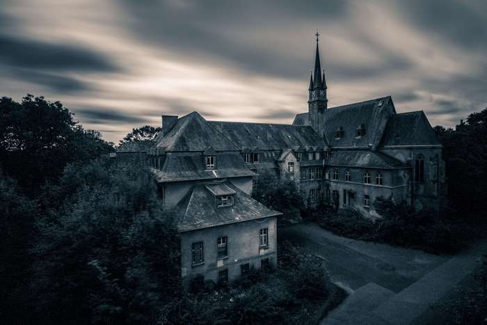 Dilapidated Gothic church and house with trees 4K