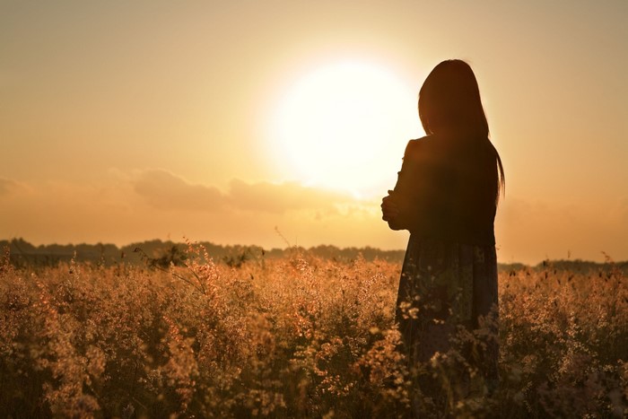 Girl in a field at sunset