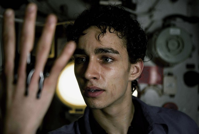 Robert Sheehan in a dark room