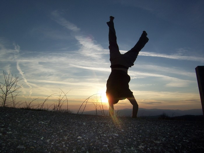 Person doing a handstand at sunset