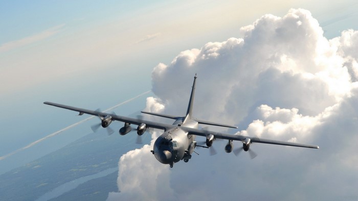 Military transport plane flying through clouds